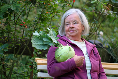 Portrait of smiling woman standing against plants