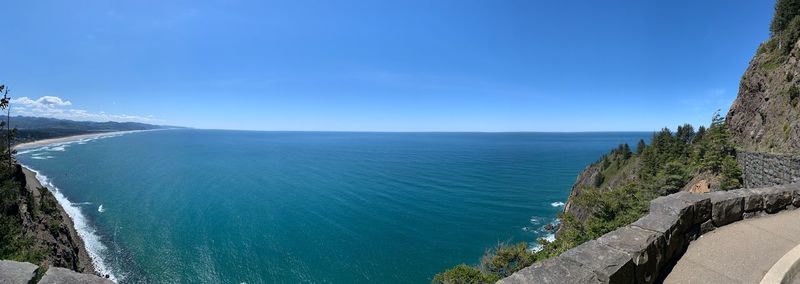 Scenic view of sea and mountains against blue sky