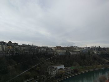 High angle view of buildings by river against sky