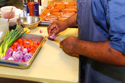 Midsection of man preparing food in kitchen