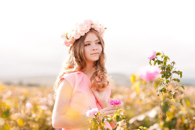 Teenager girl wearing wreath standing at farm