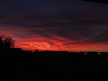 Silhouette landscape against orange sky