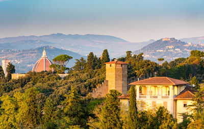 Panoramic view of trees and buildings against sky