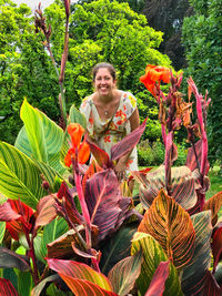 Portrait of smiling young woman holding flowering plants