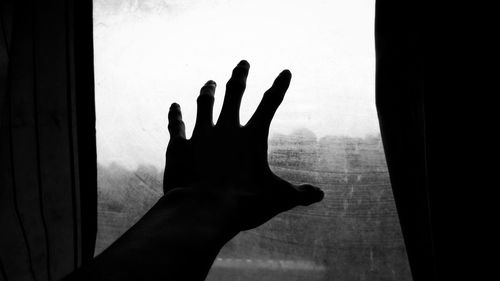 Shadow of person hand on glass window at home