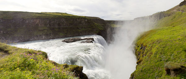Scenic view of waterfall against sky