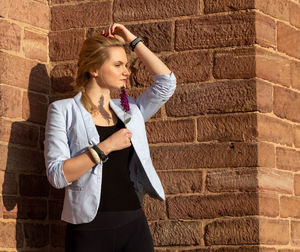 Full length of woman standing against wall