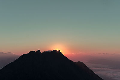 Scenic view of silhouette mountains against sky during sunset