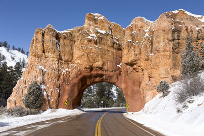 Road leading towards rocky mountains during winter