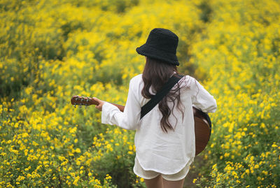 Young woman standing on yellow flowers