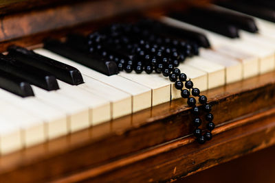 Close-up of bead necklace on piano keys