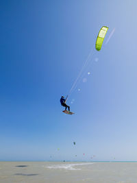 Low angle view of man kitesurfing in mid-air