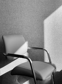 Close-up of empty chair against wall