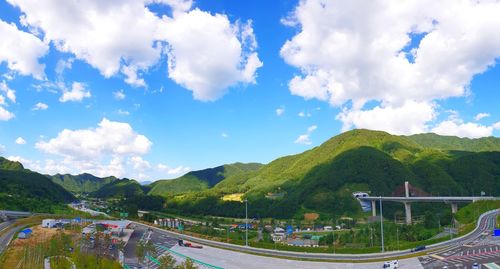 Road by trees against sky in city