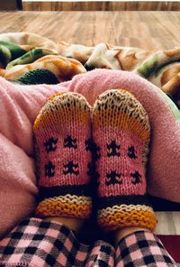 Low section of woman wearing socks on bed