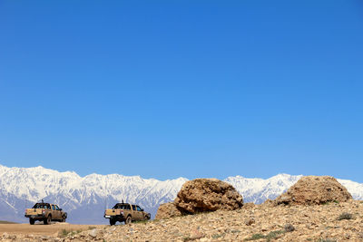 Panoramic view of field and mountains against clear blue sky