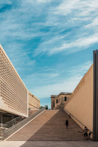 People on steps against blue sky