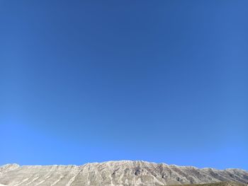 Low angle view of mountain against clear blue sky