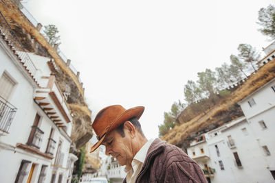 Low angle view of man looking at buildings against sky