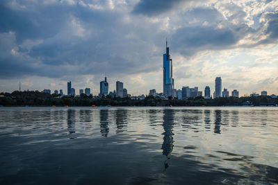 Buildings in city against cloudy sky