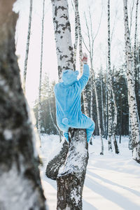 Low section of woman on tree trunk during winter