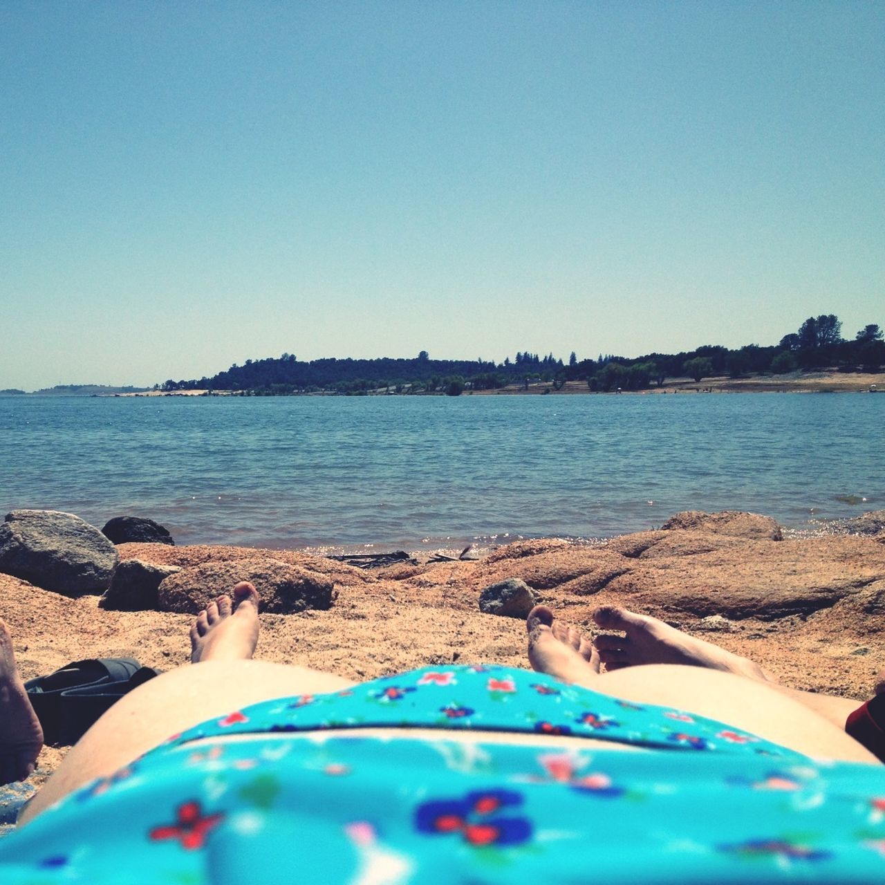 clear sky, beach, blue, water, sea, sand, relaxation, shore, copy space, leisure activity, low section, lifestyles, vacations, person, barefoot, summer, sunlight, horizon over water