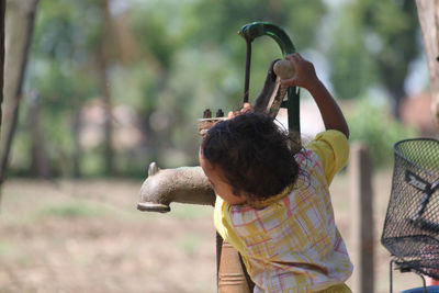 Rear view of boy holding horse