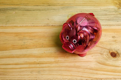 Directly above view of piggy bank on wooden table