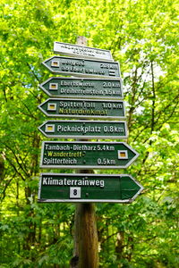 Low angle view of information sign against trees