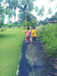 Rear view of people walking on footpath