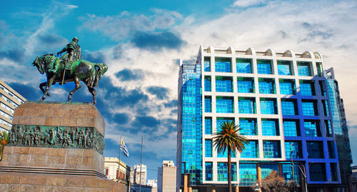 Low angle view of statue against buildings in city