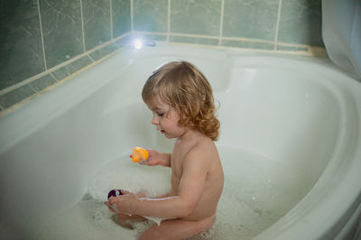 Full length of shirtless boy in bathroom at home