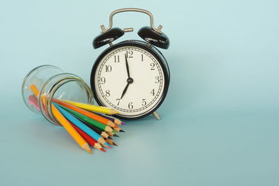Close-up of clock on table against white background