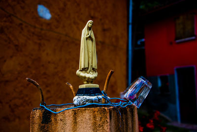 Madonna praying above a fountain with glass cup in chiampo valley, veneto, italy