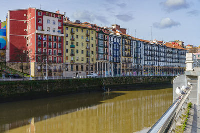 Bridge over river in city against sky
