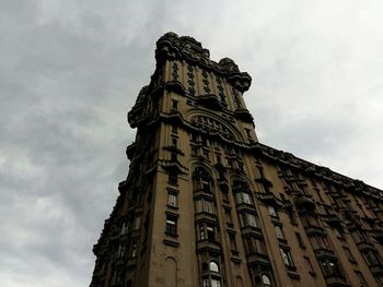 Low angle view of clock tower against cloudy sky
