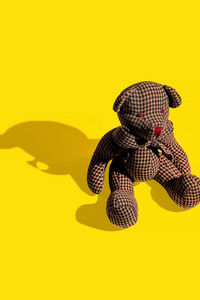 Vintage bear toy on yellow background