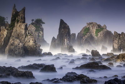 Panoramic shot of rocks in sea against sky