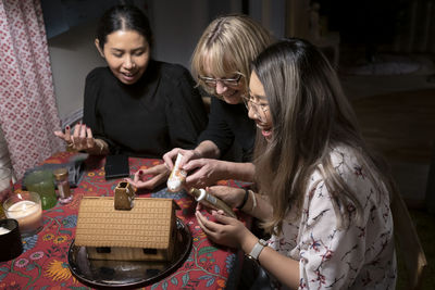 Women decorating gingerbread house