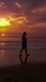 Full length of woman on beach during sunset