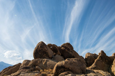 Rock formations against sky with layered clouds
