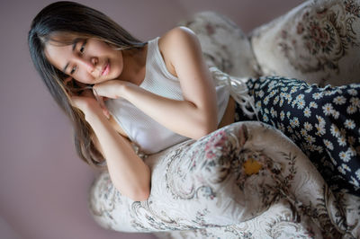 Portrait of young woman sitting at home