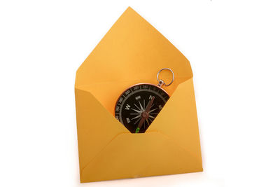 Close-up of yellow clock over white background