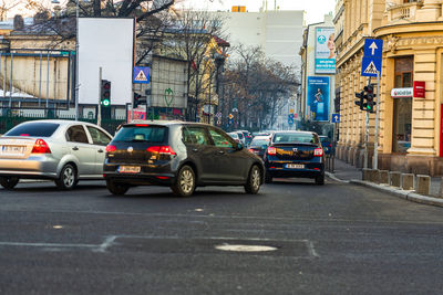 Vehicles on road by buildings in city