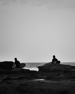 Two men at beach with surfboard