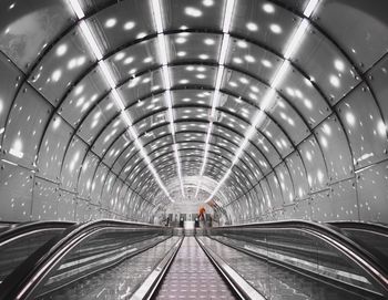 View of escalator in illuminated tunnel