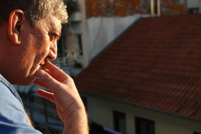 Close-up of man smoking cigarette in city