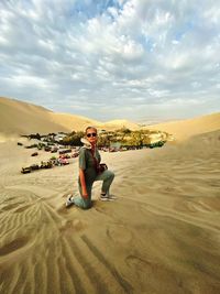 Full length portrait of senior man sitting on land