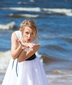 Beautiful woman blowing kiss at beach