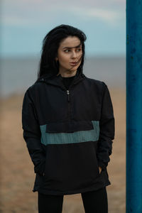 Portrait of young woman standing on field